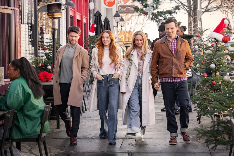 Cast photo of Our Little Secret on Netflix. A guy in a camel coat, a red haired woman in a white coat and jeans, a blond woman in a white coat andeans, and a dark hair guy in a leather jacket walk down a street in winter