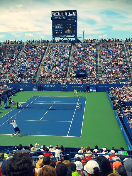 Tennis stadium overhead shot - two people play as a crowd watches