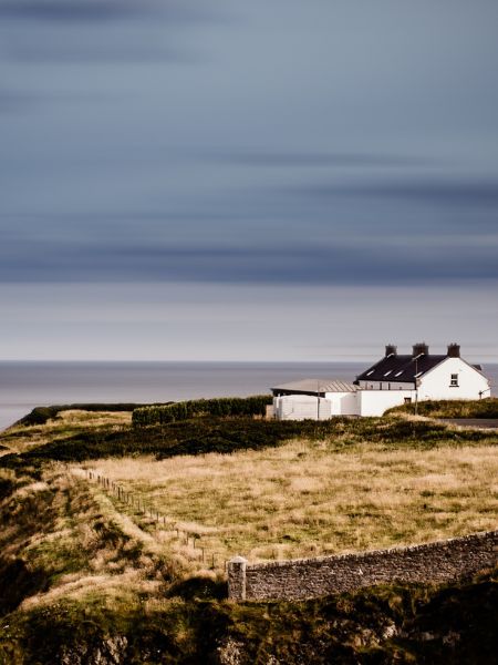 Daisy Darker takes place at a house by the sea in Cornwall. A photo of a house overlooking the sea by Jeffrey Czum/Pexels.