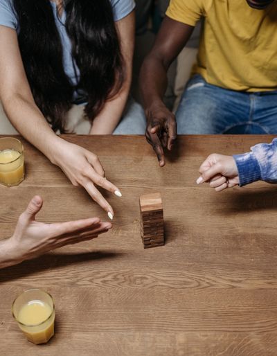 Group of people around a table playing rock paper scissors