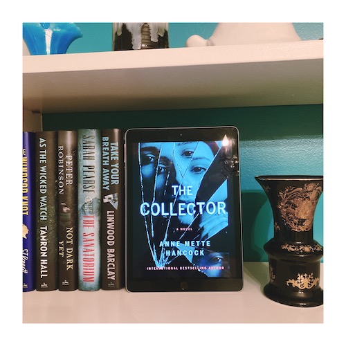 iPad with a copy of the Collector on it, sitting on a bookshelf next to a black and gold vase.