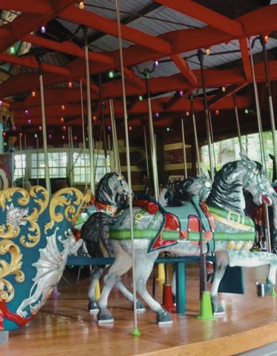 Photo of the Carousel in Central Park. Colorful painted horses spin around in a circle.