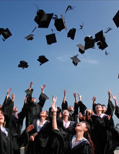 Group of graduates throwing their graduation cap s in the air.