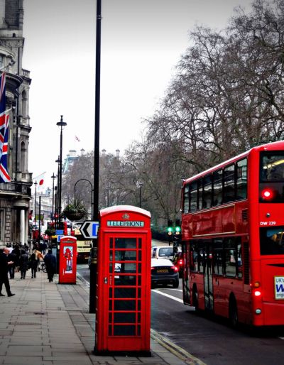 A photo of a London street with a red telephone box and a red double decker bus