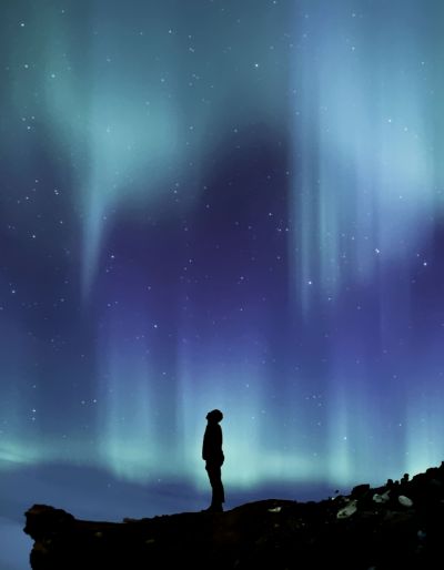 Small figure on a cliff looking at the night sky, possibly the Northern Lights.