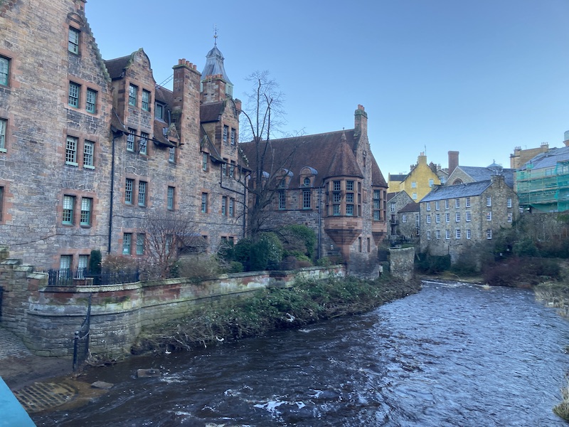 Original photo of Dean Village in Edinburgh, an old milling village next to the river Leith. Photo shows a row of old stone buildings next to the river.