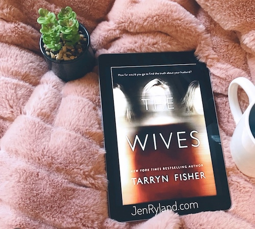 Original photo of The Wives by Tarryn Fisher. The book is on top of a fuzzy pink blanket next to a succulent.