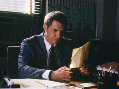 Harrison Ford playing Rusty Sabich in Presumed Innocent. Ford sits at a desk wearing a suit and studies a piece of paper