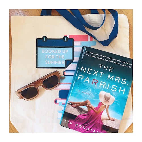 Original photo of  a copy of The Next Mrs. Parrish on top of a canvas tote that reads "Booked Up for the Summer" plus a pair of sunglasses
