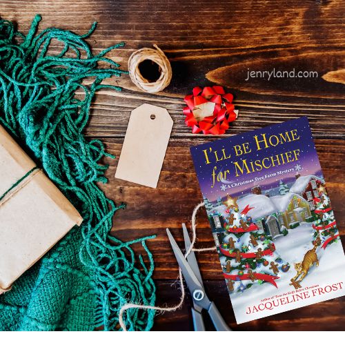 Photo of a copy of I'll be Home for Mischief on a wooden table next to gift wrapping supplies