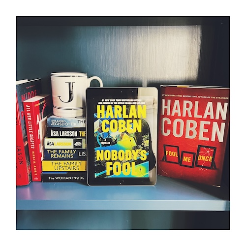 Original photo of Nobody's Fool and Fool Me Once on a bookshelf with a J mug