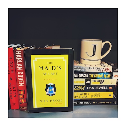 Original photo of The Maids Secret by Jen Ryland. The book is on a shelf next to other yellow books and a J mug