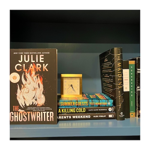 Original photo of The Ghostwriter by Julie Clark on a shelf with other thriller and a clock