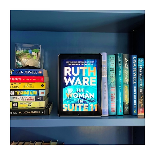 Original photo of The Woman in Suite 11. Copy of the book on a dark blue bookcase with other blue books