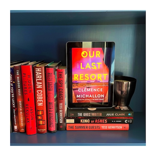 Original photo of Our Last Resort on a shelf next to other red and orange books
