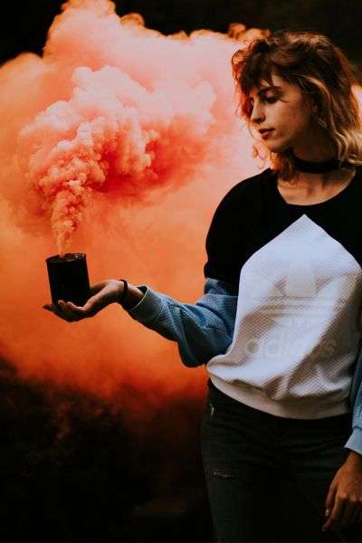 Photo of a woman holding a box with an explosion behind her