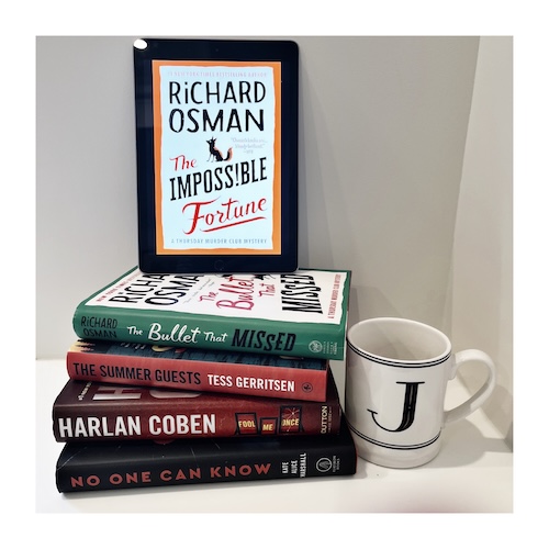 The cover of The Impossible Fortune with a group of orange books.