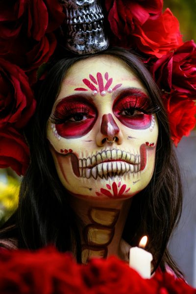 Woman with a white and red painted face for the Day of the Dead