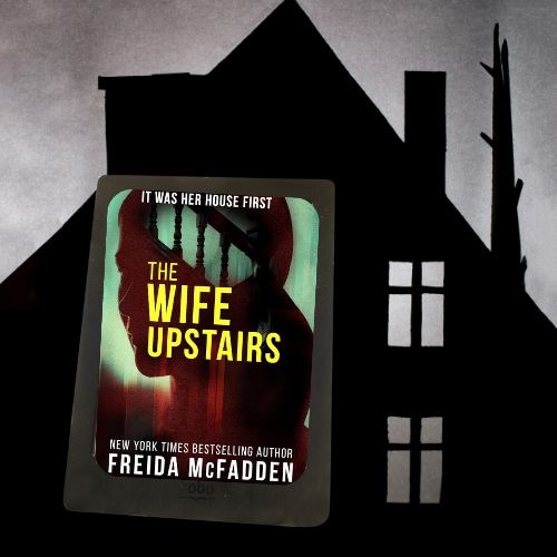 The cover of The Wife Upstairs by Freida McFadden superimposed over a dark silhouette of a house.