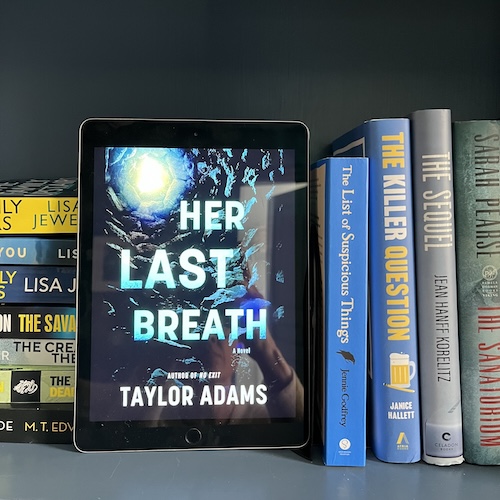 Photo of Her Last Breath by Taylor Adams on a bookshelf next to blue and yellow books